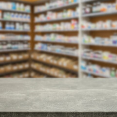 Empty wooden counter with copy space in front of blurred pharmacy shelves with medicines....
