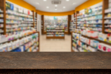 Empty wooden counter with copy space in front of blurred pharmacy shelves with medicines....