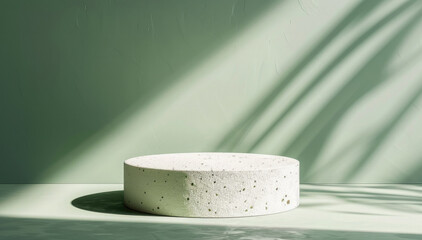 Minimalistic white round podium placed in soft natural light with shadows from leaves on a light green background. The mockup is suitable for presentation or product installation