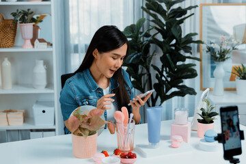 Young beautiful Asian reviewing cosmetic makeup and skin care collection, talking customer on...