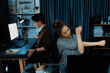 Businesswoman working on desk with stretching arm up and down manner with body health ache of...