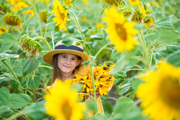 little girl in sunflowers in a field