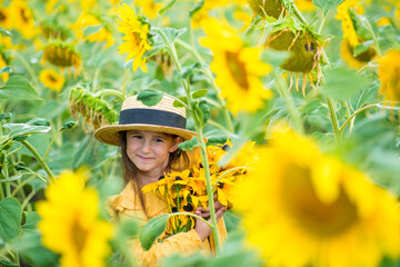 little girl in sunflowers in a field