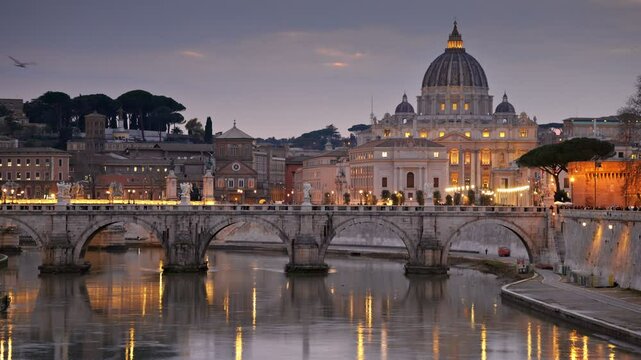 Evening shot of St. Peter's Basilica and Sant Angelo Bridge in Vatican, Rome, Italy. Birds fly at sunset against the backdrop of evening Rome with city lights. HDR shot