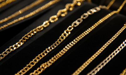 Elegant display of gold chains showcasing various styles and designs on black velvet.