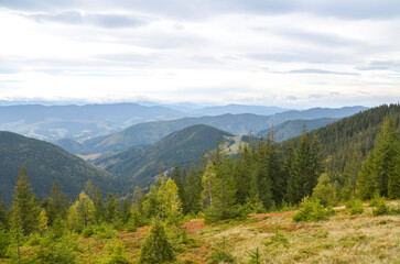Beautiful landscape featuring a valley lined with vibrant green forests, rolling hills, and distant...
