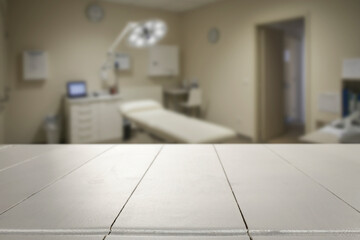 Empty wooden table with copy space in front of blurred doctor's office interior. Preventive care,...