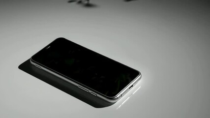 Sleek smartphone rotation with dramatic shadows showcasing modern technology design