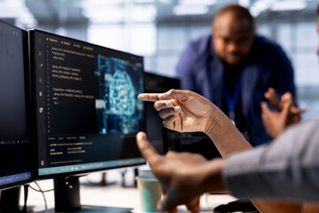 Server farm admin showing colleague AI technology on computer, creating and implementing...