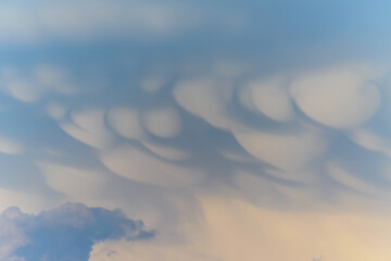 Unique cloud formations display dramatic textures during sunset over the landscape