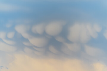 Unique cloud formations display dramatic textures during sunset over the landscape