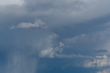 Dark storm clouds gathering above the horizon before a summer rainfall in a rural landscape