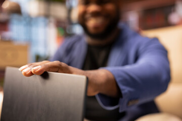 Young man closing the laptop to urge his partner for some time to unwind and relax, sharing a warm...