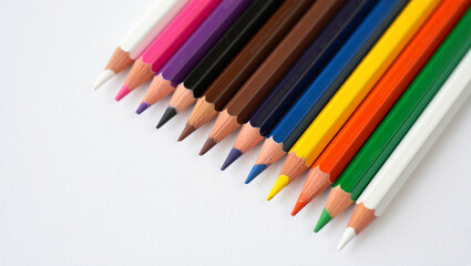Fototapeta premium Colored Pencils Lined Up On A White Surface