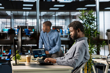 Confident black general manager multitasking at the office and solve administrative tasks on his...
