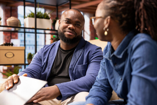 Black man and woman pause their remote job for a moment of affection and rest. Young couple taking a break together to help maintain balance, avoid burnout and enhance their relationship.