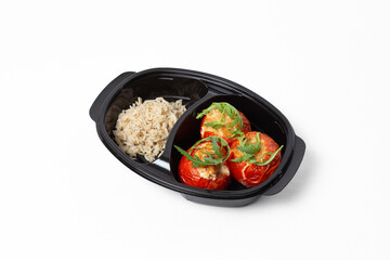 Stuffed baked tomatoes with boiled rice on a plate against a white background