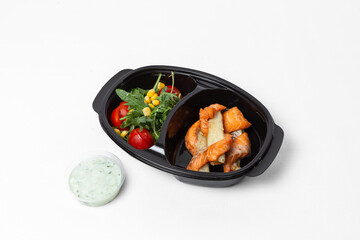 Red fish skewers with tomatoes, arugula, corn, and tartar sauce on a plate against a white background