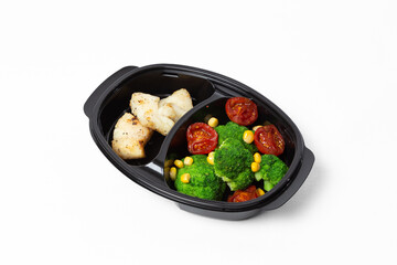 White fish skewers with broccoli, roasted tomatoes, and corn on a plate against a white background