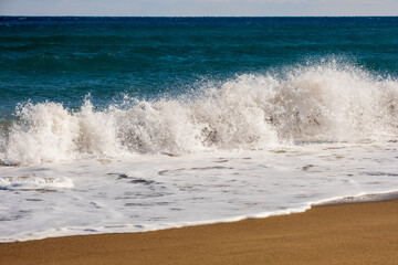 Sea wave breaks on sandy beach with clouds sky on Mediterranean coast of Mersin province, Atakent
