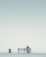 Man sitting on a bench in a minimalist setting contemplating life