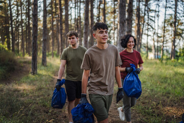 family of volunteers pick up waste garbage and walk through from forest