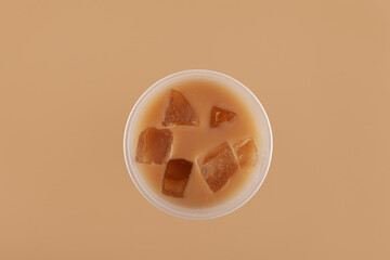 Hong kong milk tea mixed with iced ersatz coffee in disposable plastic cup, top view. Refreshing...