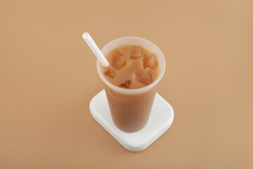 Hong kong milk tea mixed with iced ersatz coffee in disposable plastic cup. Refreshing cold drink. Take away street food beverage
