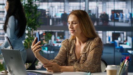 Businesswoman participates in a virtual meeting via video call, discussing project objectives and...