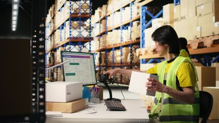 Asian warehouse worker scanning shipping labels and barcodes on packages, using scanner to verify shipment details on parcels before distribution. Man works near racks with hi vis vest. Camera A.