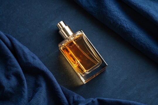 Perfume bottle mockup on a dark blue background. - Powered by Adobe
