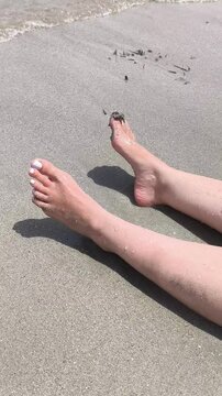 Pues de mujer relajados en la orilla del mar