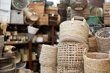 Stack bale pile of wicker baskets, large and small, stand on top of each other in store of homemade...