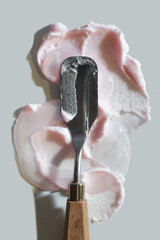 Pink beauty product balm, cream, wax, lotion with spatula isolated on grey