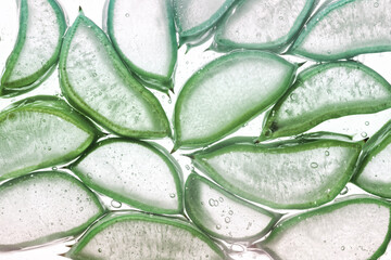 Aloe vera textured slices with sparking water or gel on white background. Beauty product or drink ingredient
