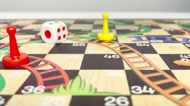 Slow motion video of a hand rolling a dice on a board game. Board game with friends concept