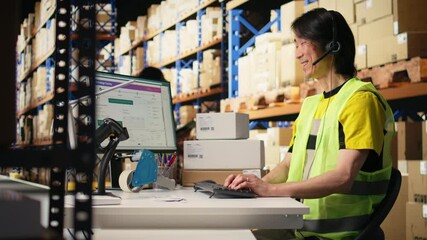 E-commerce support clerk responding to problems like lost parcels or order tracking, surrounded by cargo boxes on racks in a distribution hub. Call center operations on headset. Camera A.