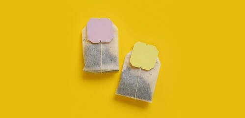 Tea bags on yellow background, top view