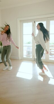 Music starting, Diverse female friends holding mics stepping and spinning at home karaoke session