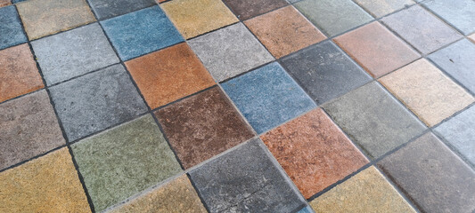 A pattern of square tiles in various colors and textures.	
