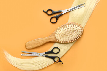 Hair strand with brush and scissors on orange background