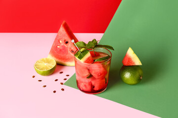Glass of fresh watermelon lemonade with lime and mint on colorful background