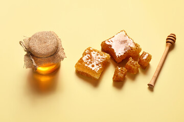 Jar of sweet honey and combs on yellow background
