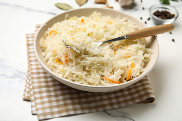 Bowl with delicious sauerkraut on white background