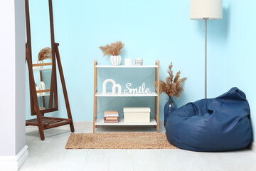 Interior of modern living room with bean bag chair, floor lamp and shelving unit