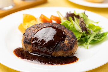 ソースがかかったハンバーグと彩り野菜の盛り付け