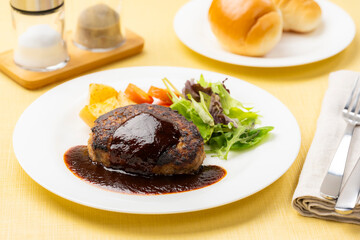 ハンバーグステーキと付け合わせ野菜とパンの洋食セット