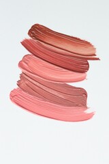 Colorful lip glosses on white background, flat lay