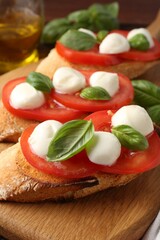 Tasty sandwiches with mozzarella cheese, tomatoes and basil on table, closeup