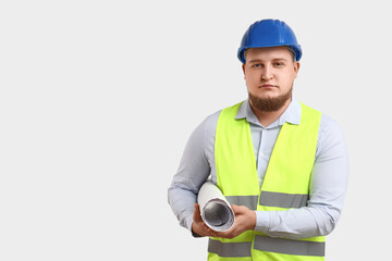 Young male engineer with drawing on light background